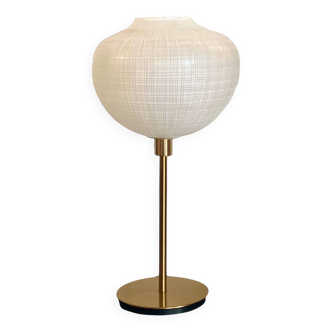 Table lamp with a white striped glass globe lampshade and a gold base