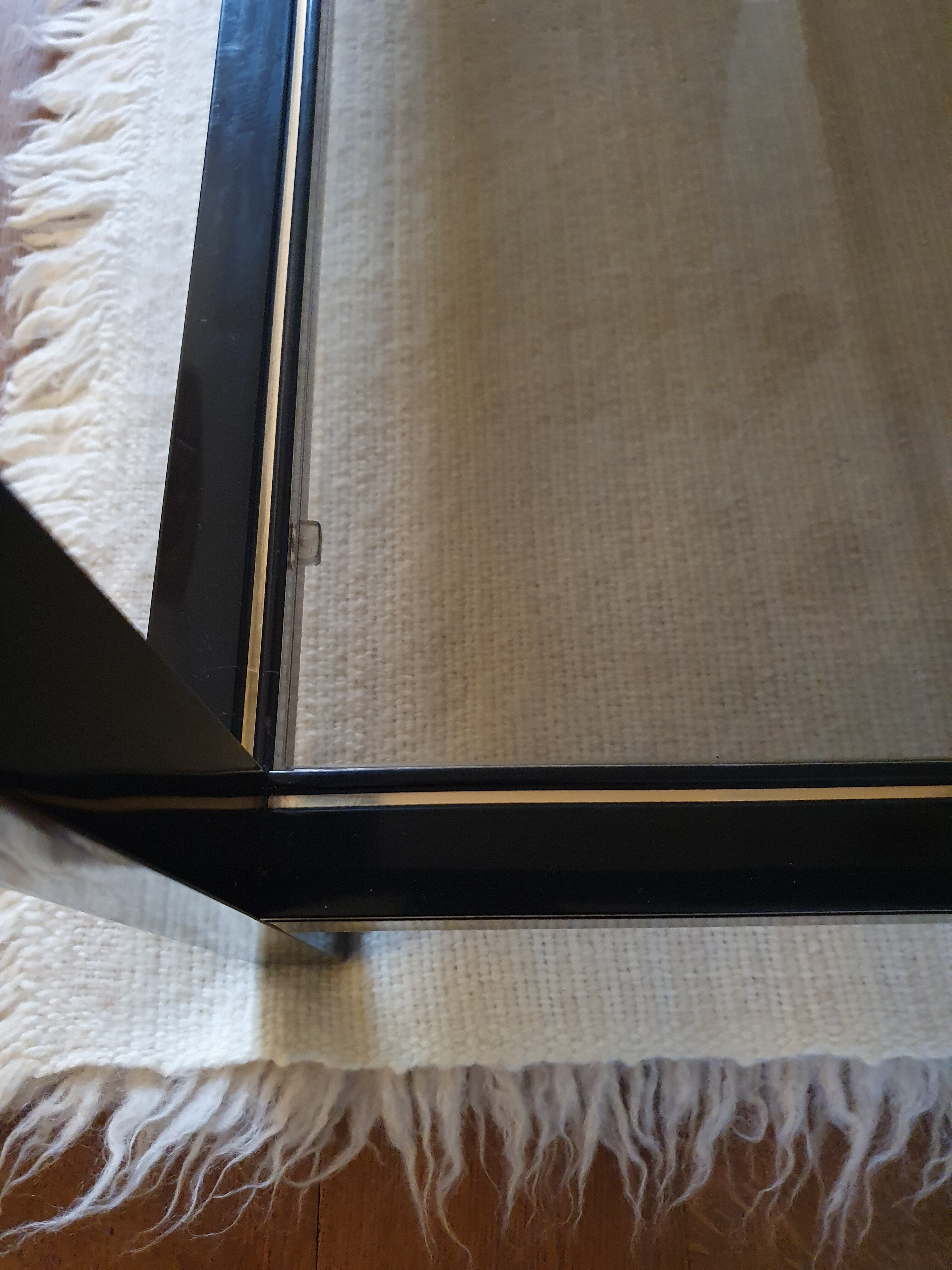 Black and gold coffee table with a double smoked glass top