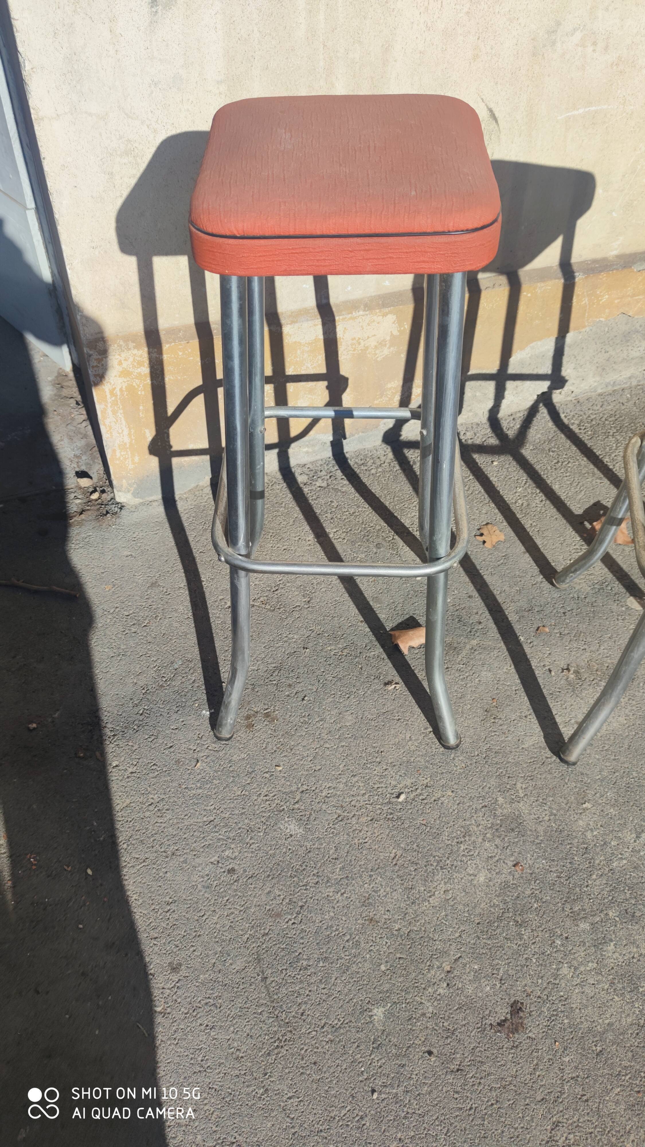Pair of aluminum bar stools with orange and black seats