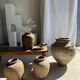 Very large grey and red terracotta pot with handles and rattan crossbars.