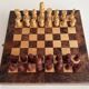 Old wooden chess set with a folding wooden box.