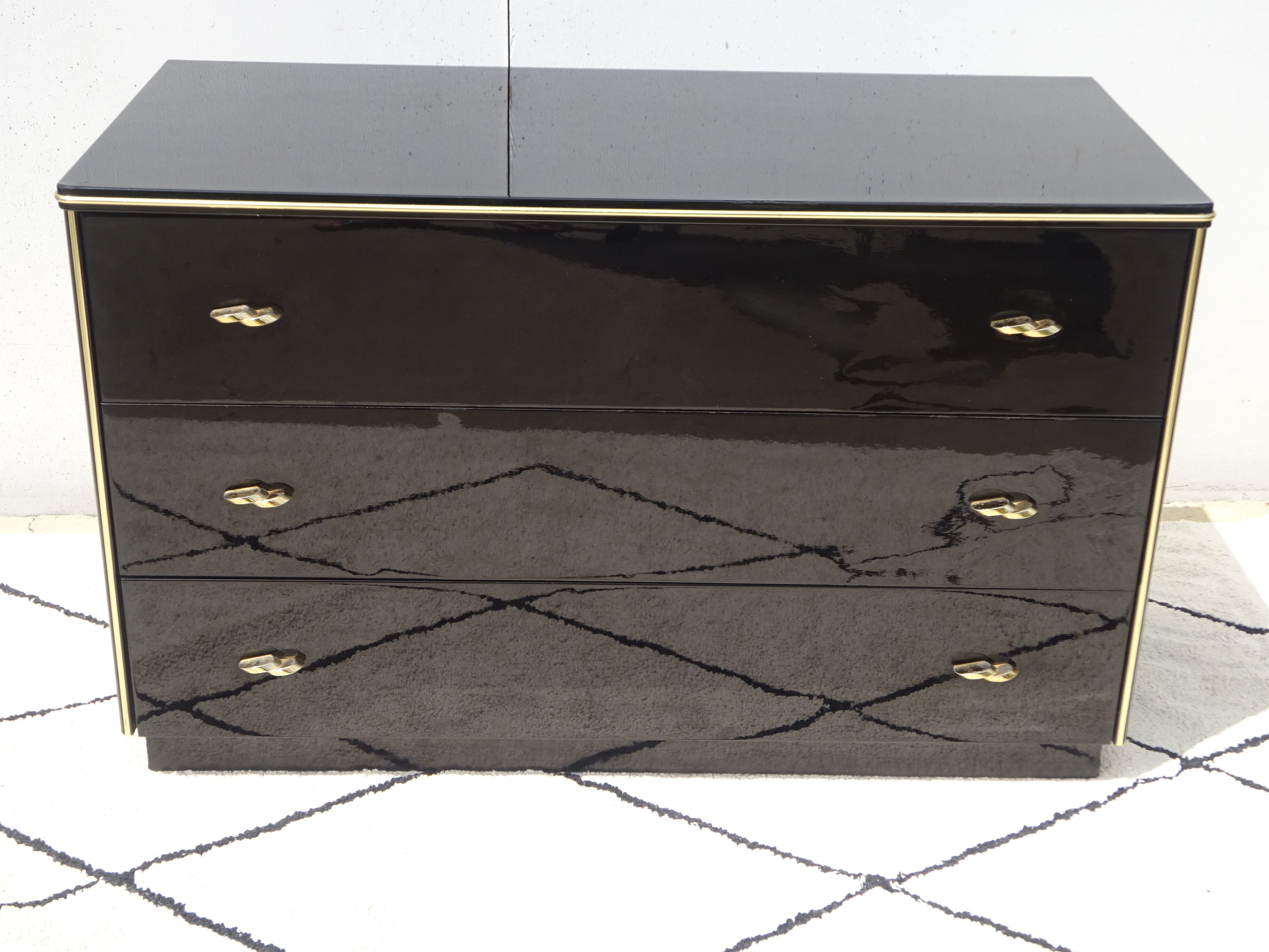 Lacquered black chest of drawers, golden brass