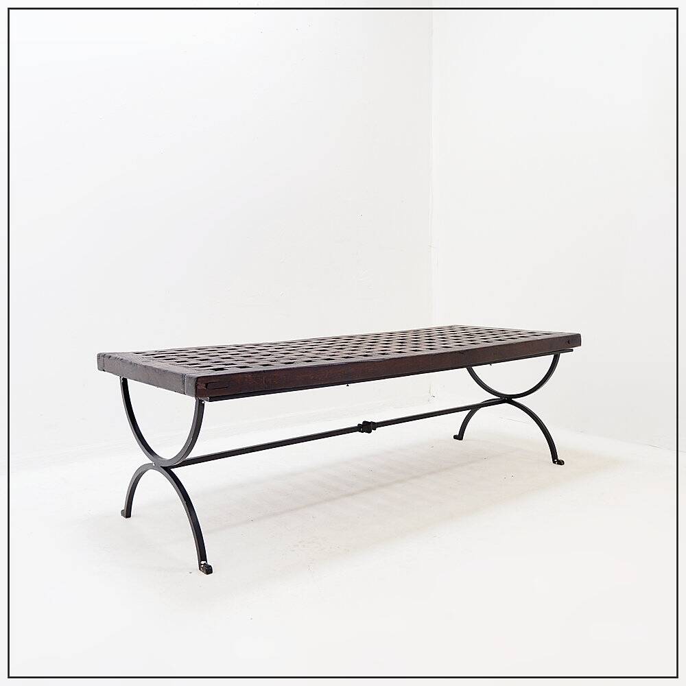 Solid wood coffee table with an openwork design and wrought iron legs.