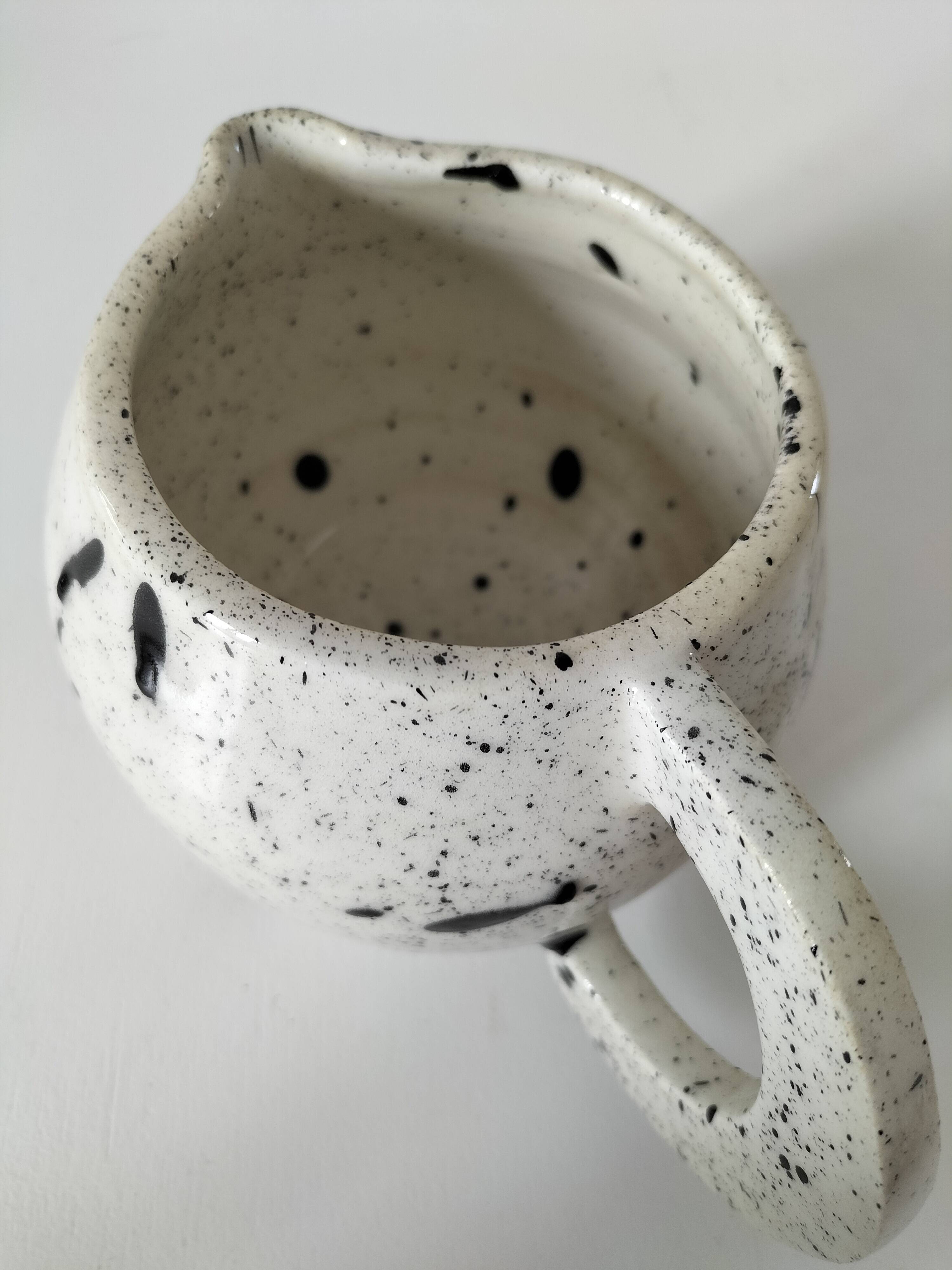 Small speckled ceramic jug in a vintage workshop style.