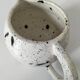 Small speckled ceramic jug in a vintage workshop style.