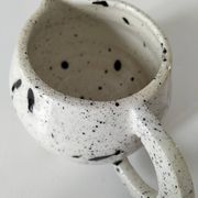 Small speckled ceramic jug in a vintage workshop style.