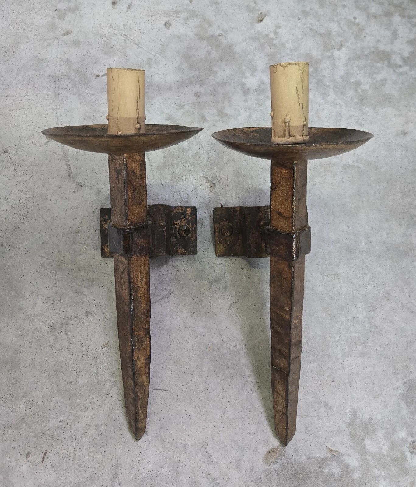 Pair of brutalist wall sconces in hammered and patinated iron, work from the years.