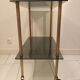Vintage rolling dessert trolley with smoked glass trays and a golden base.