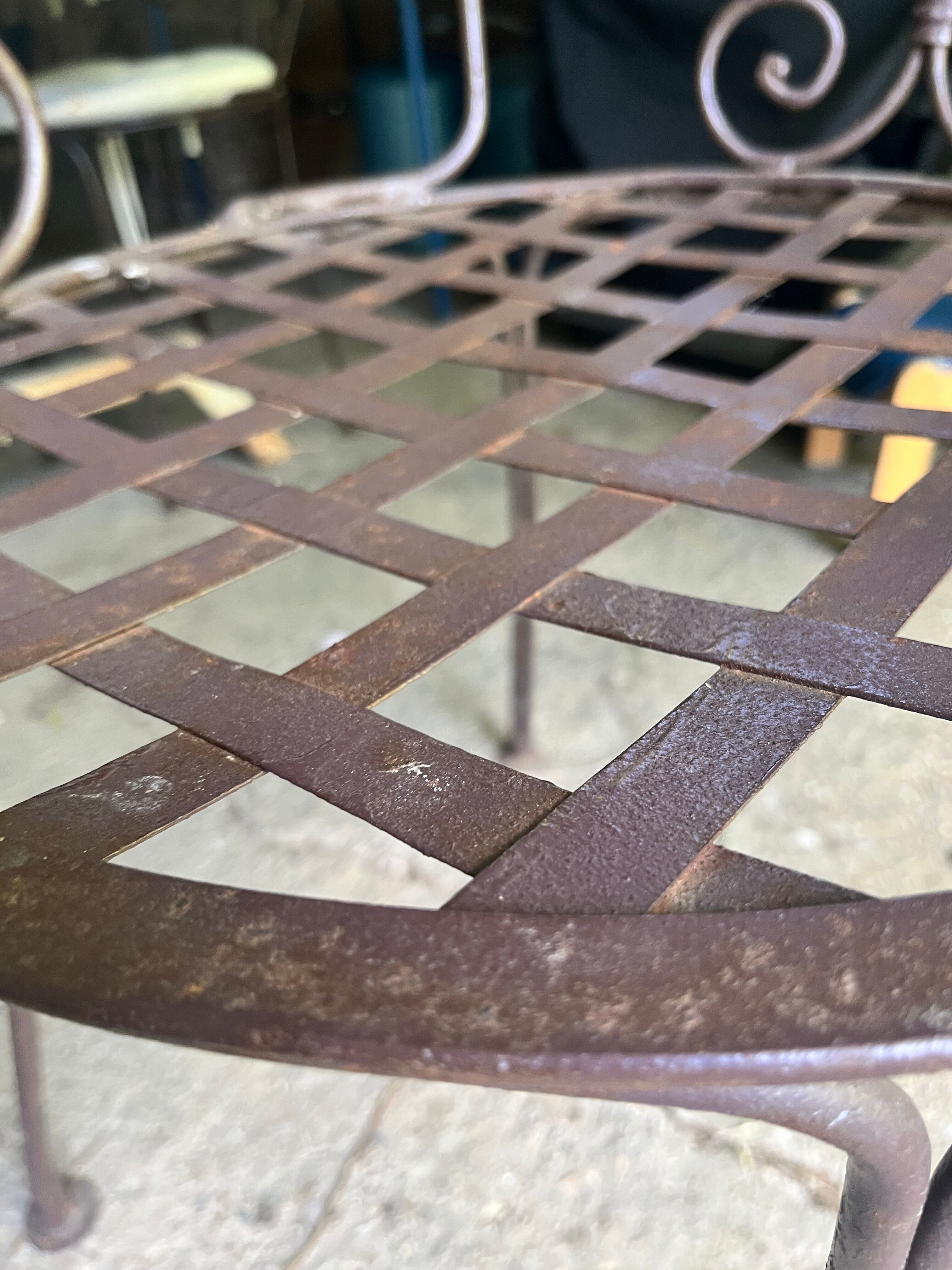 Old wrought iron table and its armchairs and chairs for outdoor use.