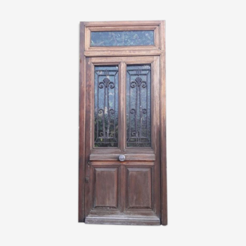 Oak entrance door and its frame and transom, wrought iron gates