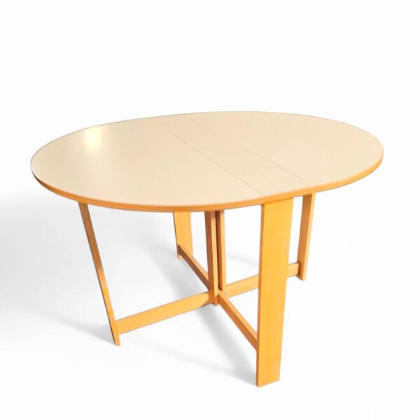 Table à manger pliante scandinave vintage avec rallonges latérales. Le plateau ovale est