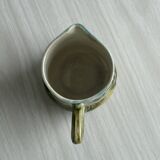 Green slip milk jug with floral patterns.