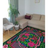 Handwoven colorful Romanian carpet, green and black background with gorgeous colorful flowers