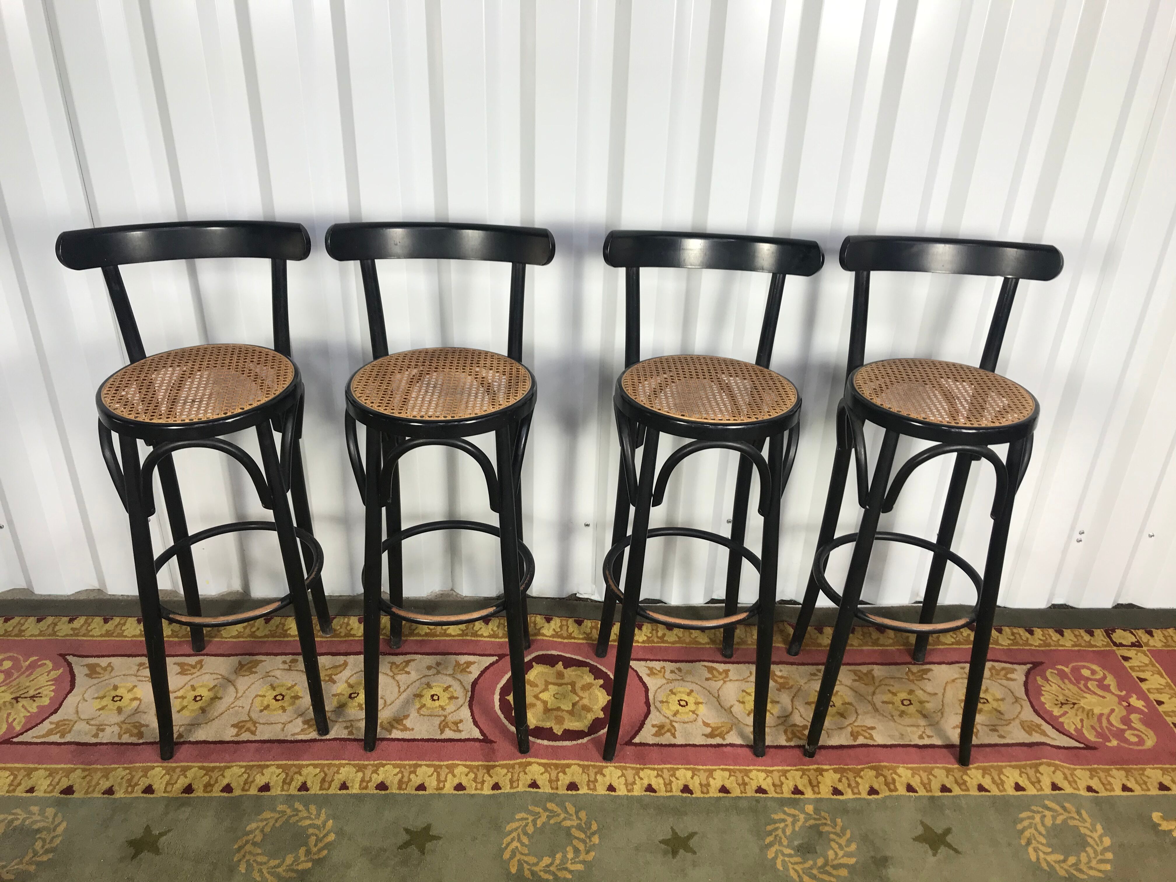 Suite de 4 tabourets de bar en cannage et bois noirci