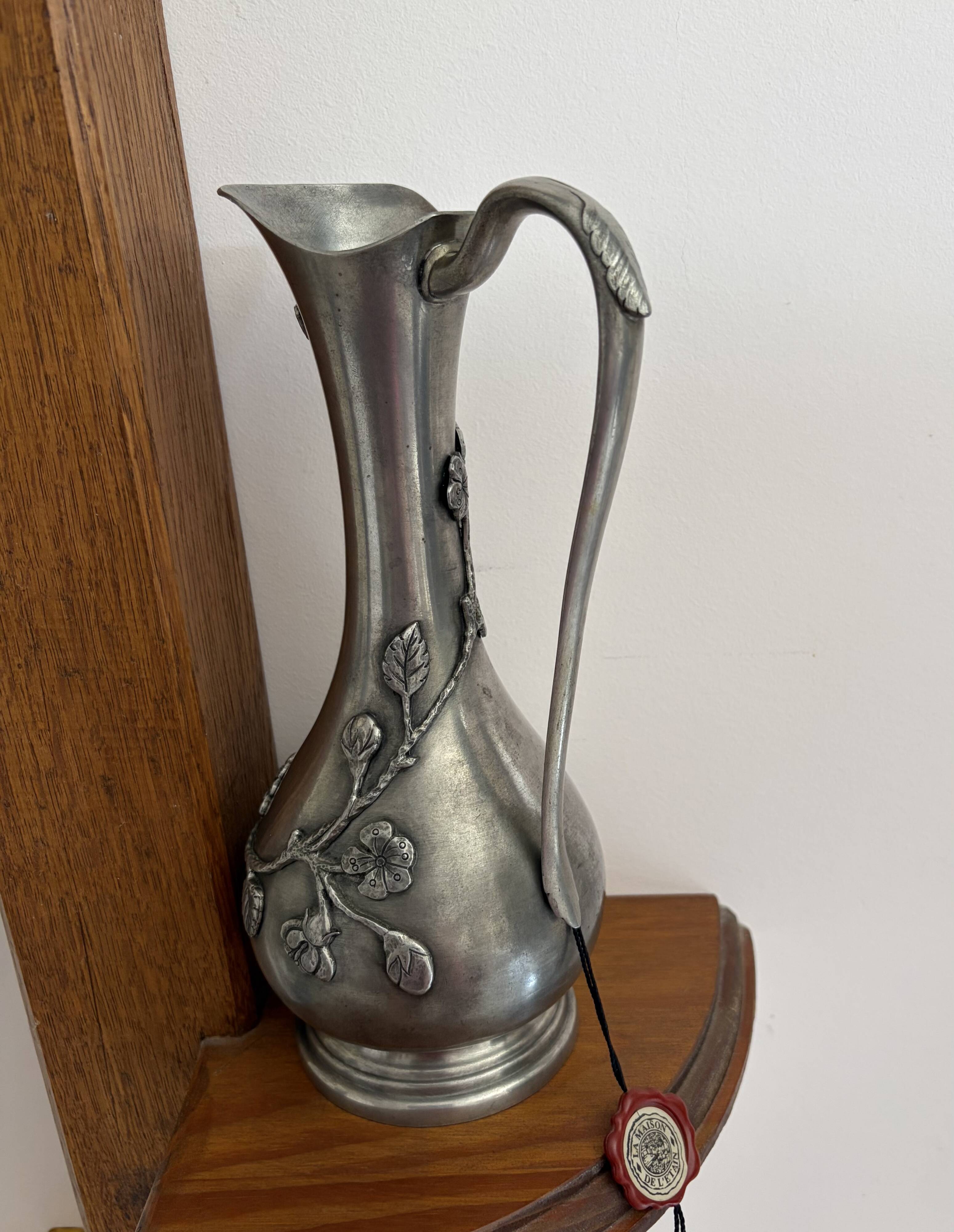 Carafe The House of Tin surrounded by ivy branches.