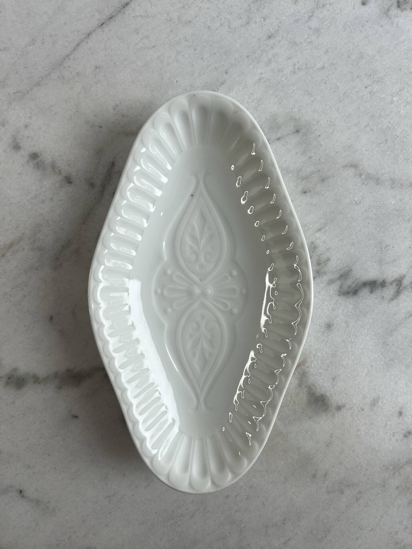 Oval white porcelain ramekin — raised floral pattern