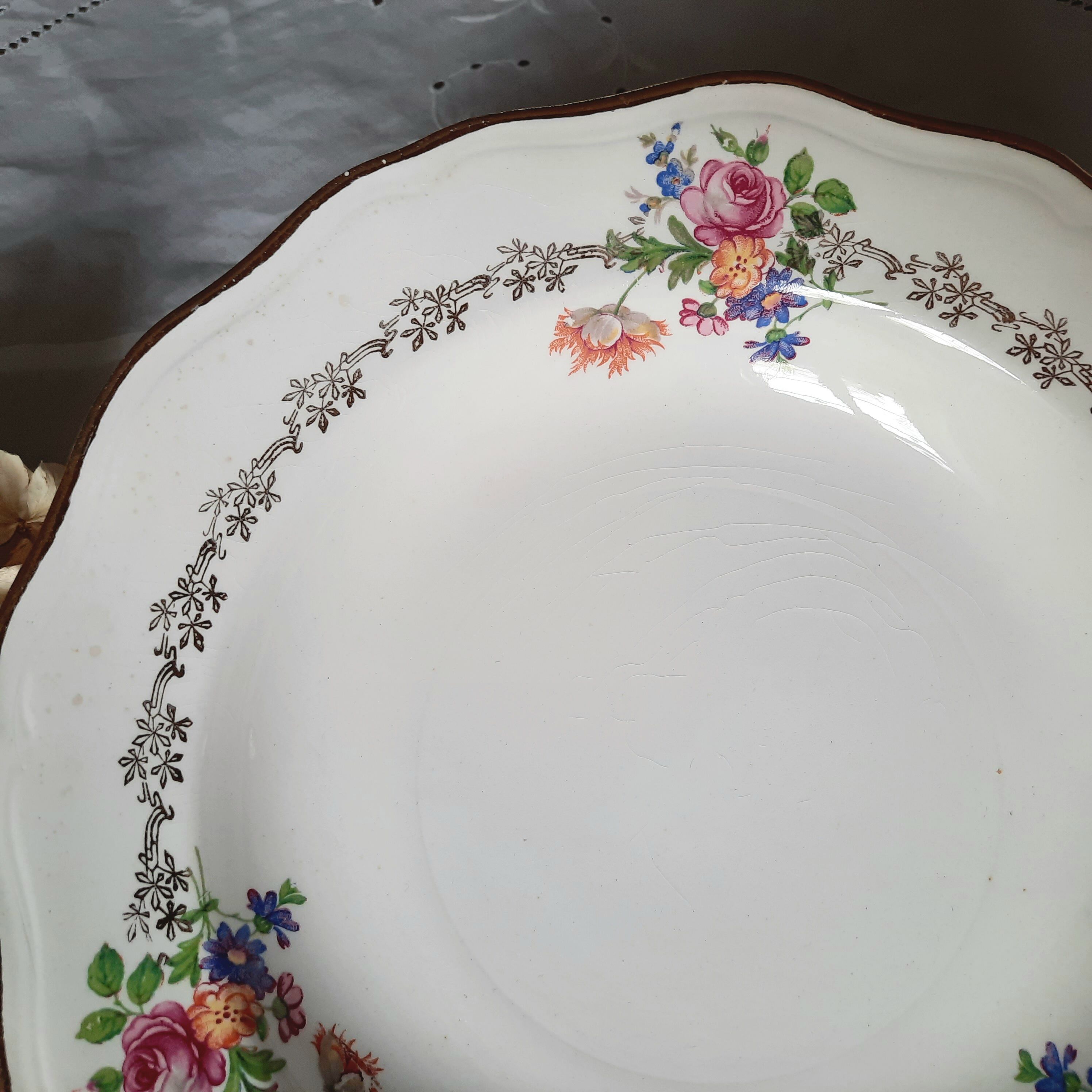 Old hollow plates mismatched in earthenware with gilded edges