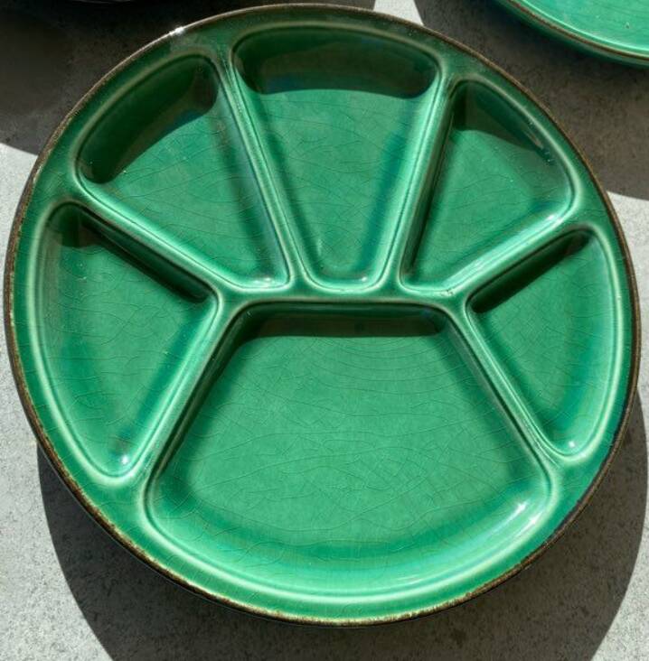 Many glazed stoneware plates with compartments.