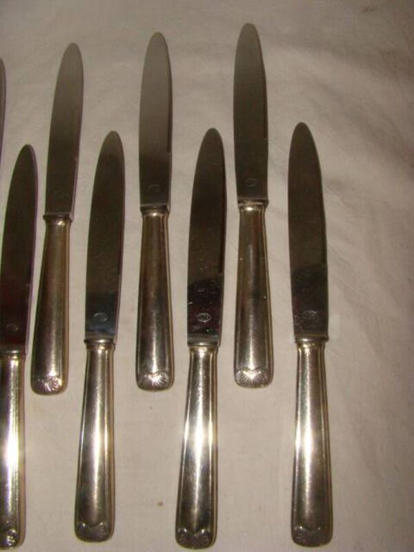 12 couteaux de table en métal argenté et inox, début XXème