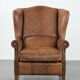 Cognac-coloured wingback armchair in English style made of cowhide leather