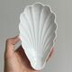 Set of white porcelain ramekins, ribbed shell shape.