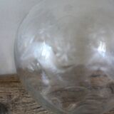 Antique glass carafe with a round belly and floral neck.