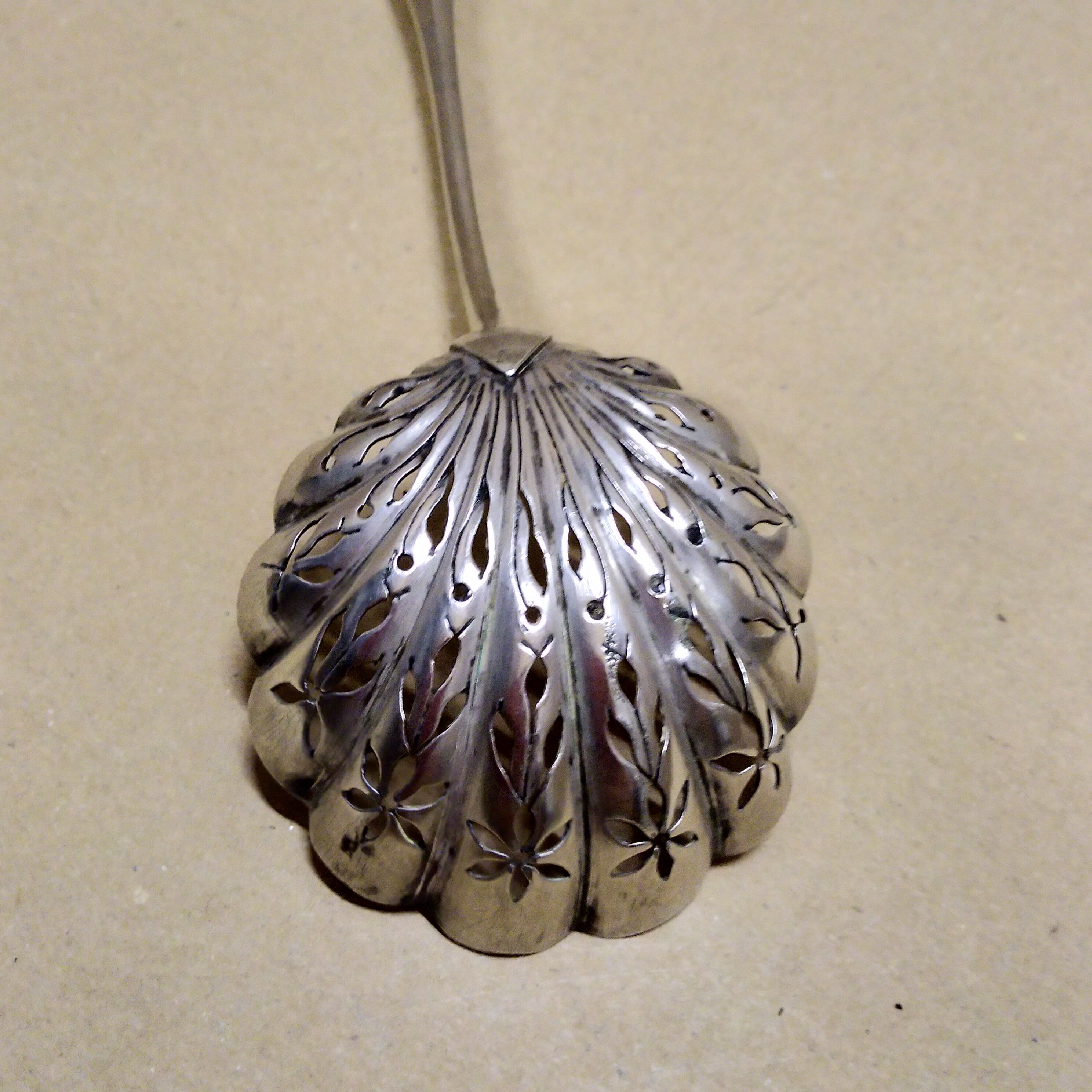 Service spoon cut out of silver metal