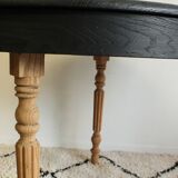 Round black dining table with oak wood.
