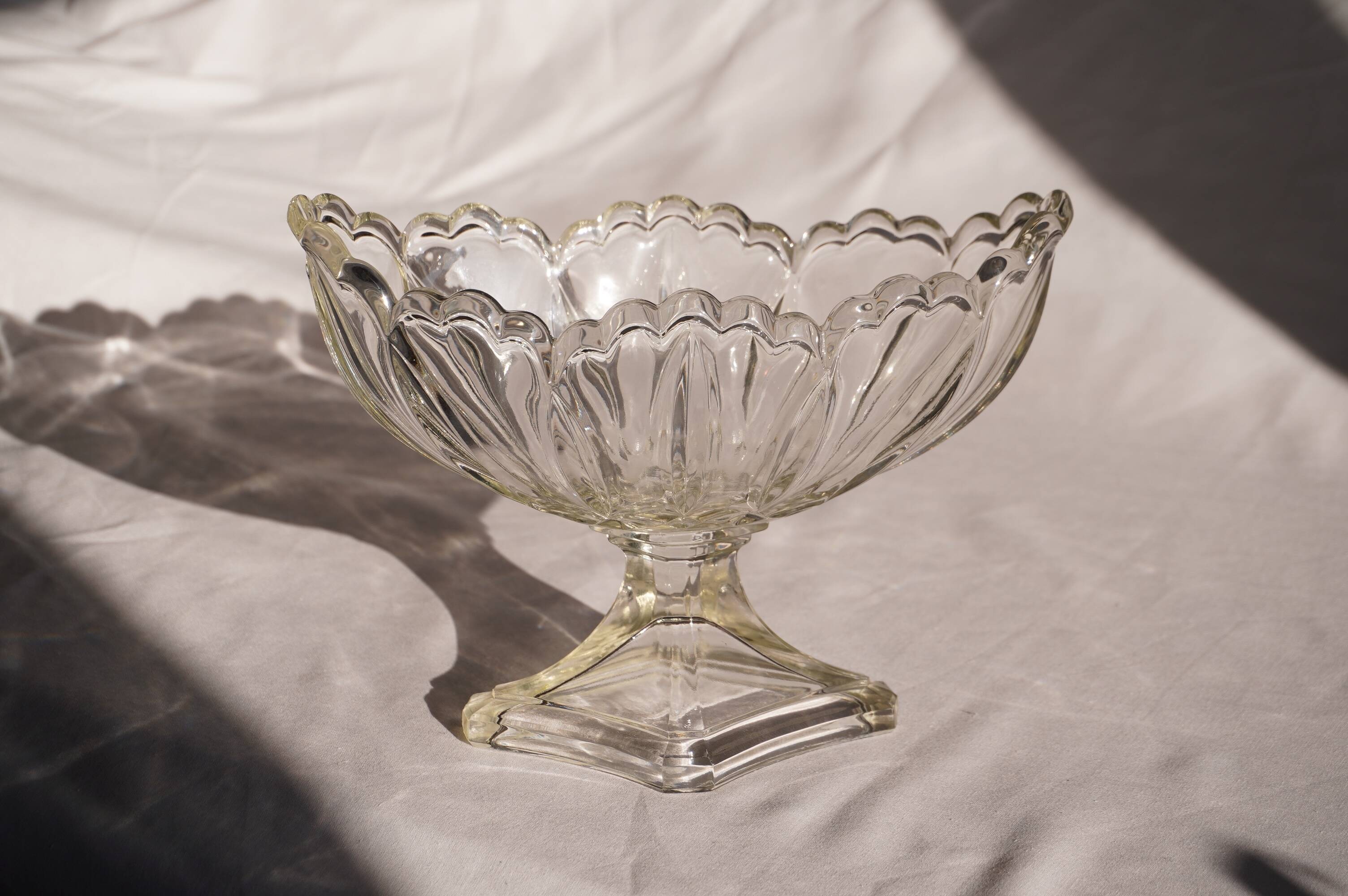 Oval glass fruit bowl on a stand.
