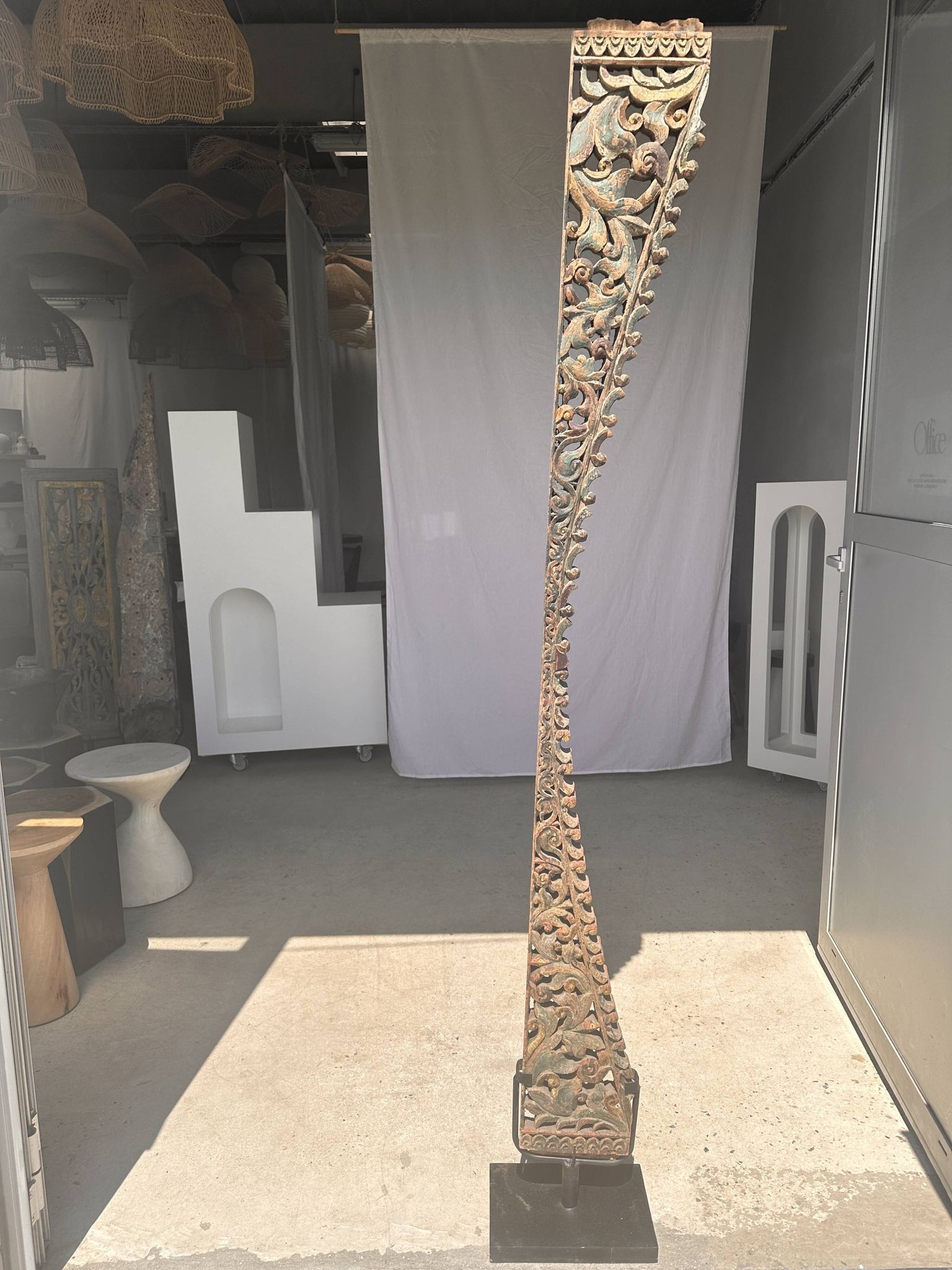 Indonesian construction element in carved wood with intertwined plant motifs mounted on a base (fri