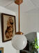 Opaline white globe pendant light with metal stem, Art Deco style.
