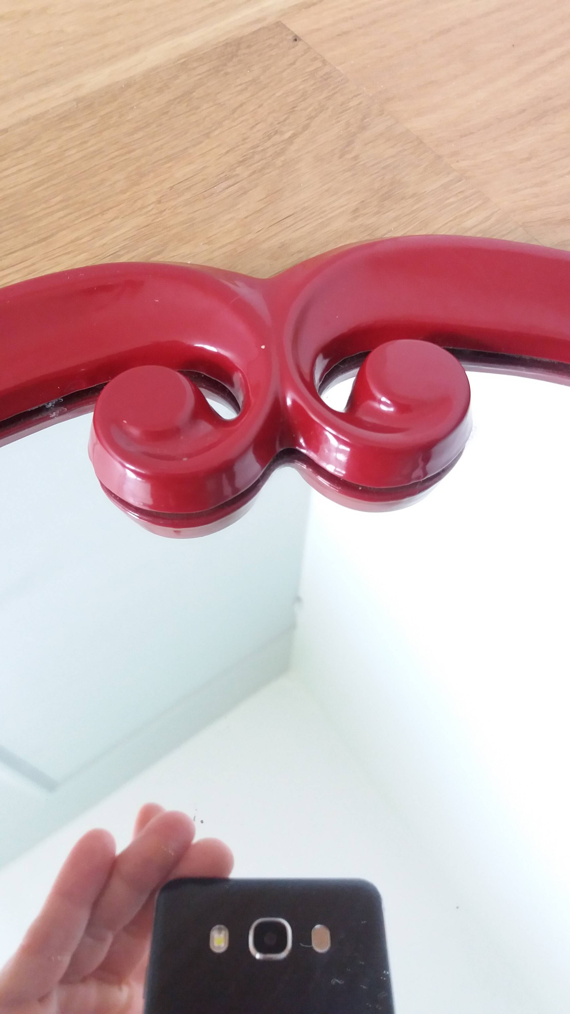 Oval mirror, red enamelled metal in Art Deco style, 49 x 39 cm.