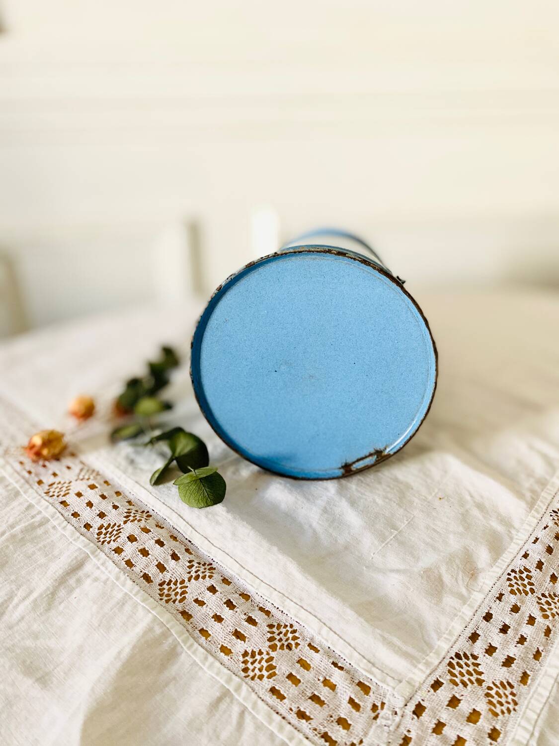 Old vintage milk jug in degraded blue enameled sheet metal