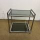 1970s coffee table in brass with a double smoked glass top.