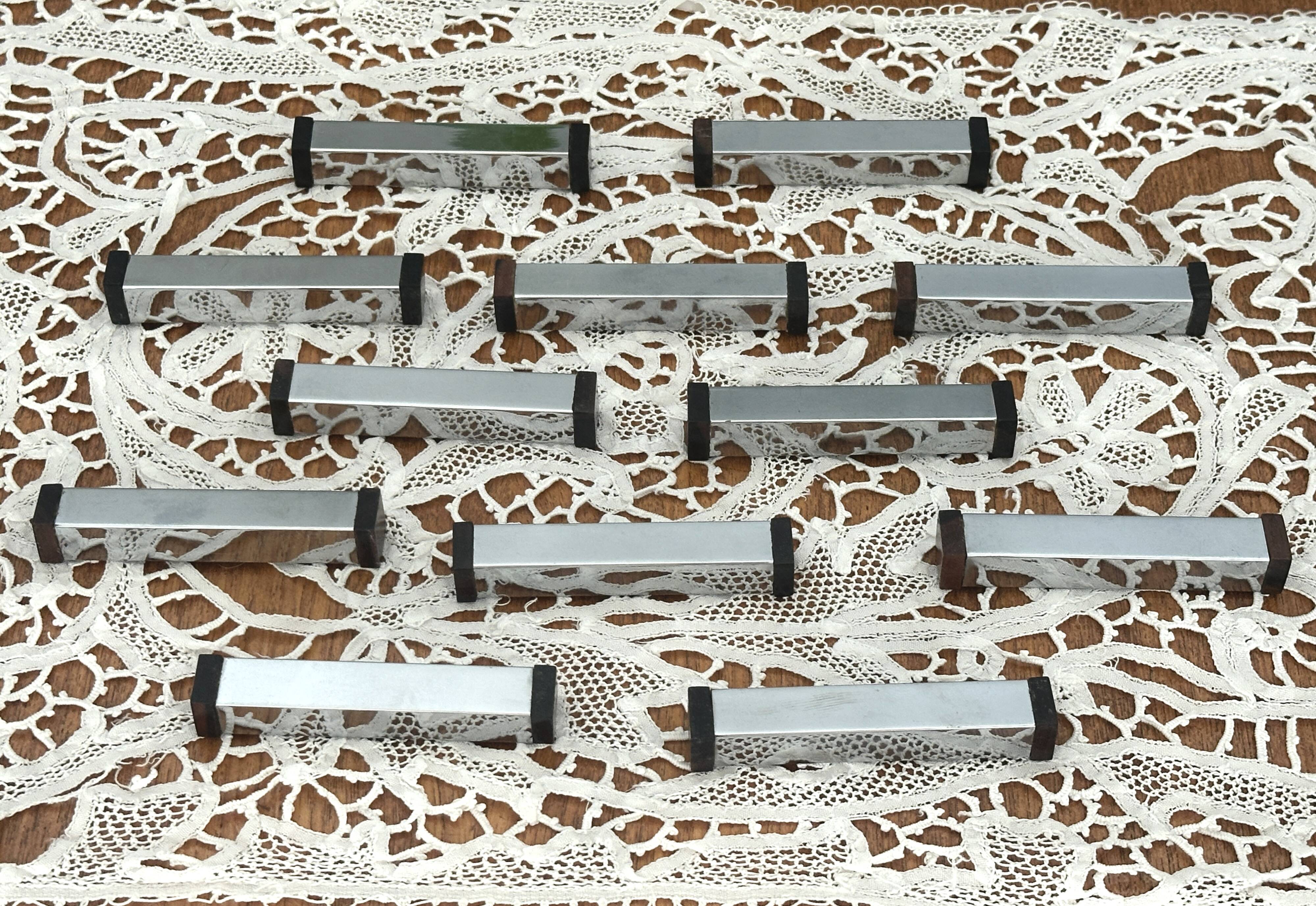 Set of 12 Art Deco Modernist knife rests in chrome metal and blackened wood.
