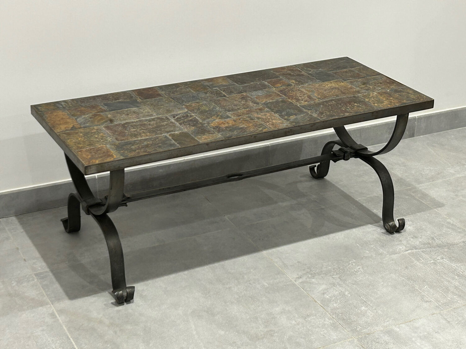 Brutalist-style coffee table made of mixed wrought iron and stone.