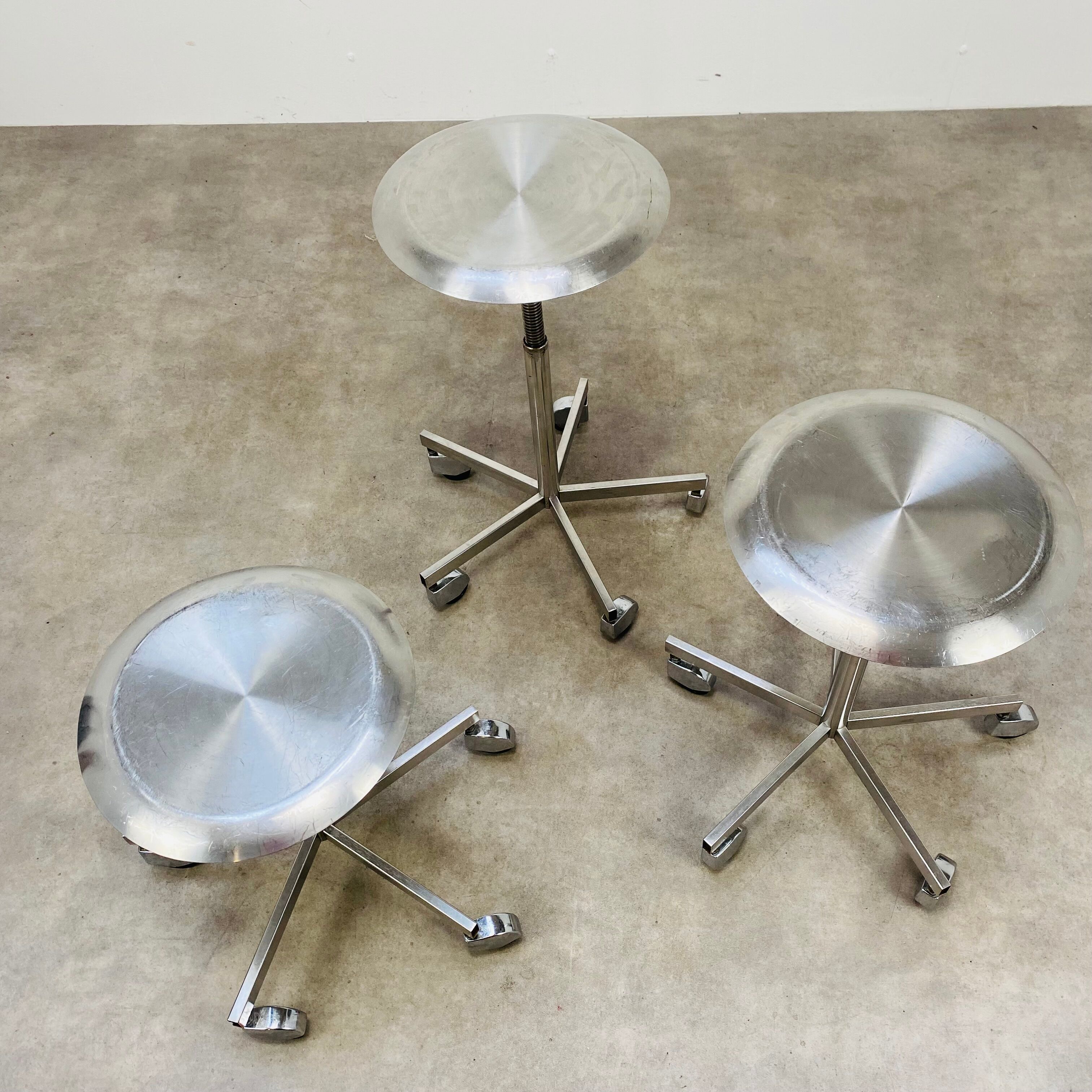3 adjustable industrial stools with aluminum wheels