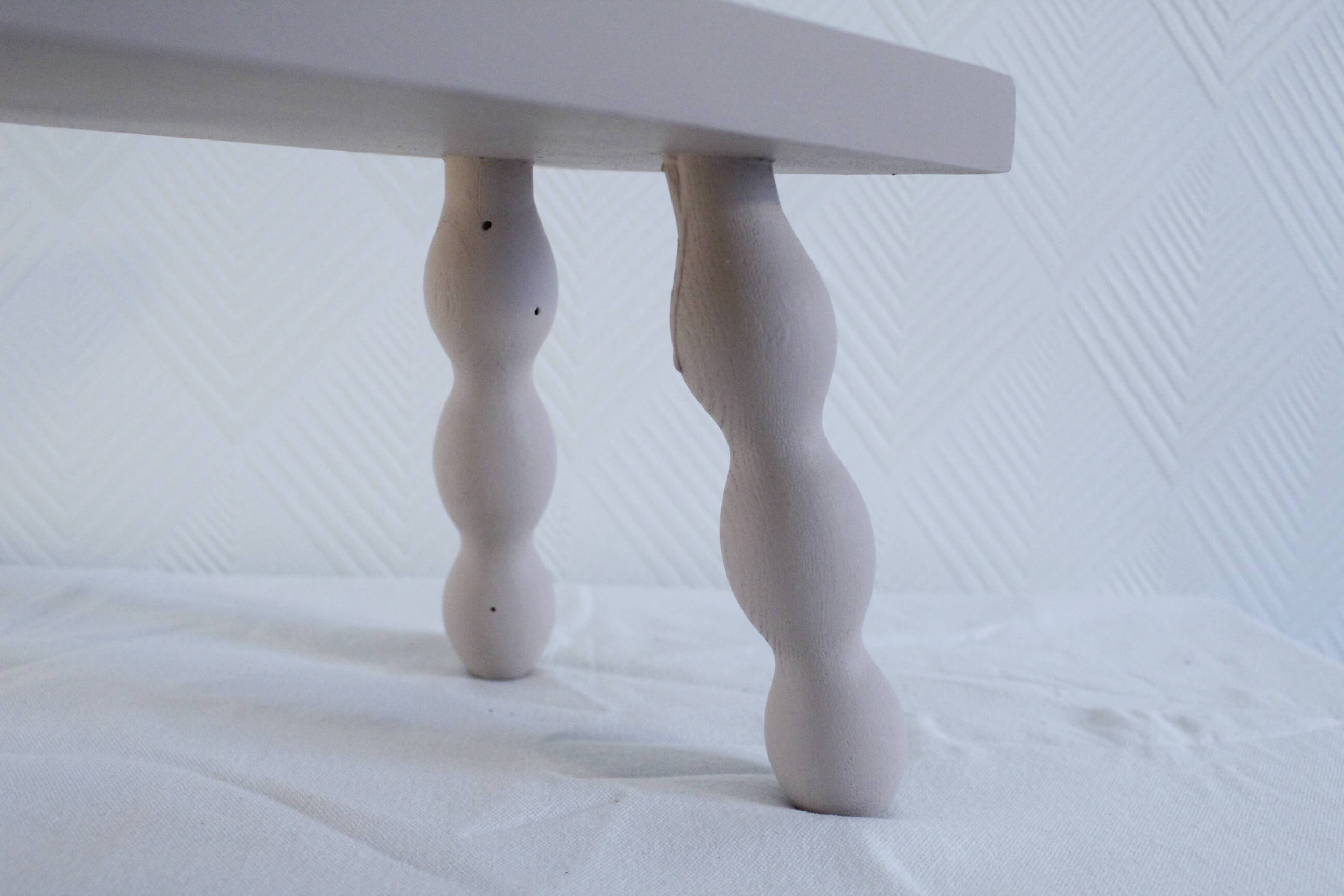 Small vintage wooden bench renovated in pinkish beige