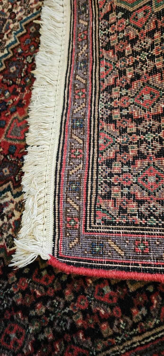 Ancient Persian carpet, wool, red tones, hand-knotted.