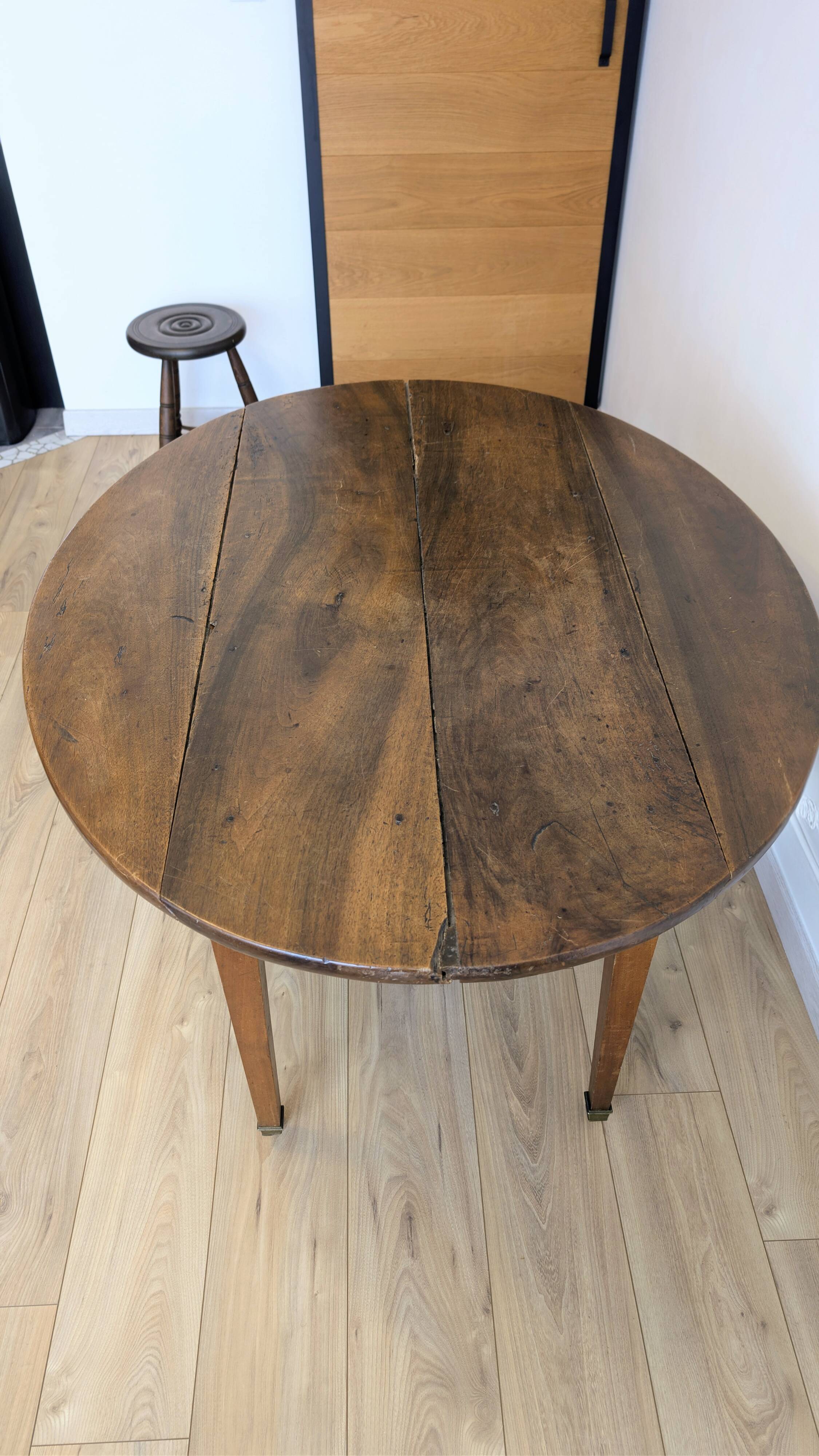 Antique wooden folding table with a patina and brass wheels.