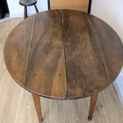 Antique wooden folding table with a patina and brass wheels.