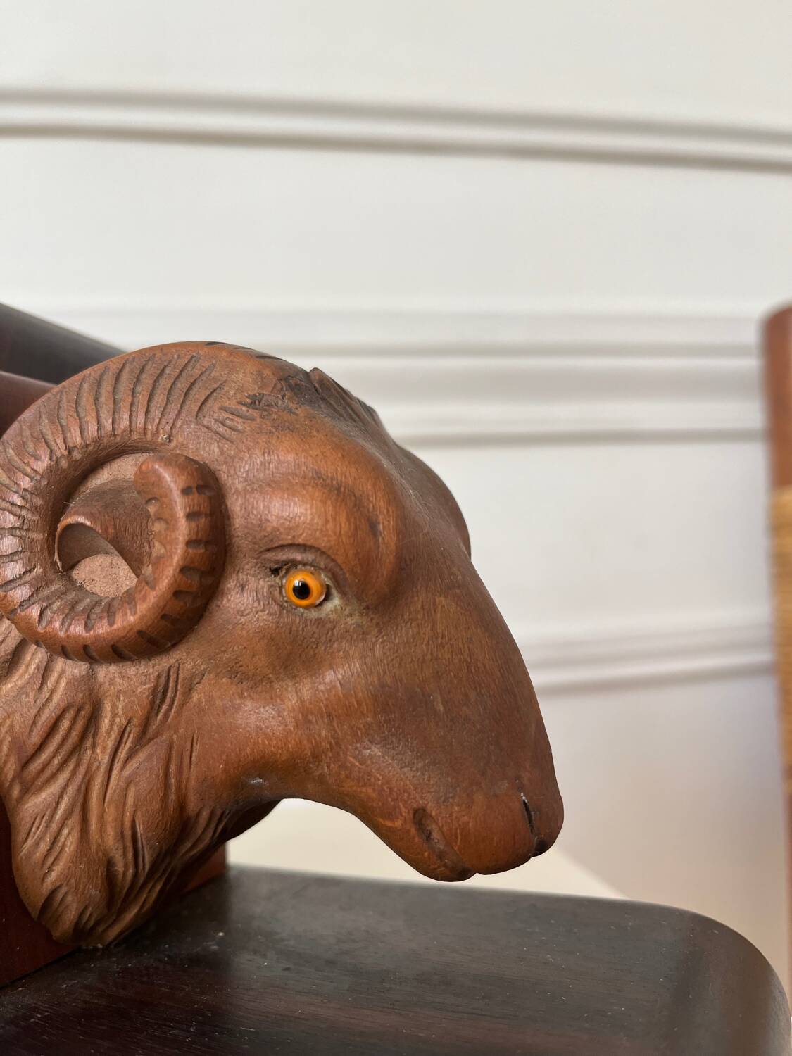 Pair of carved wooden bookends in the shape of ram's heads.