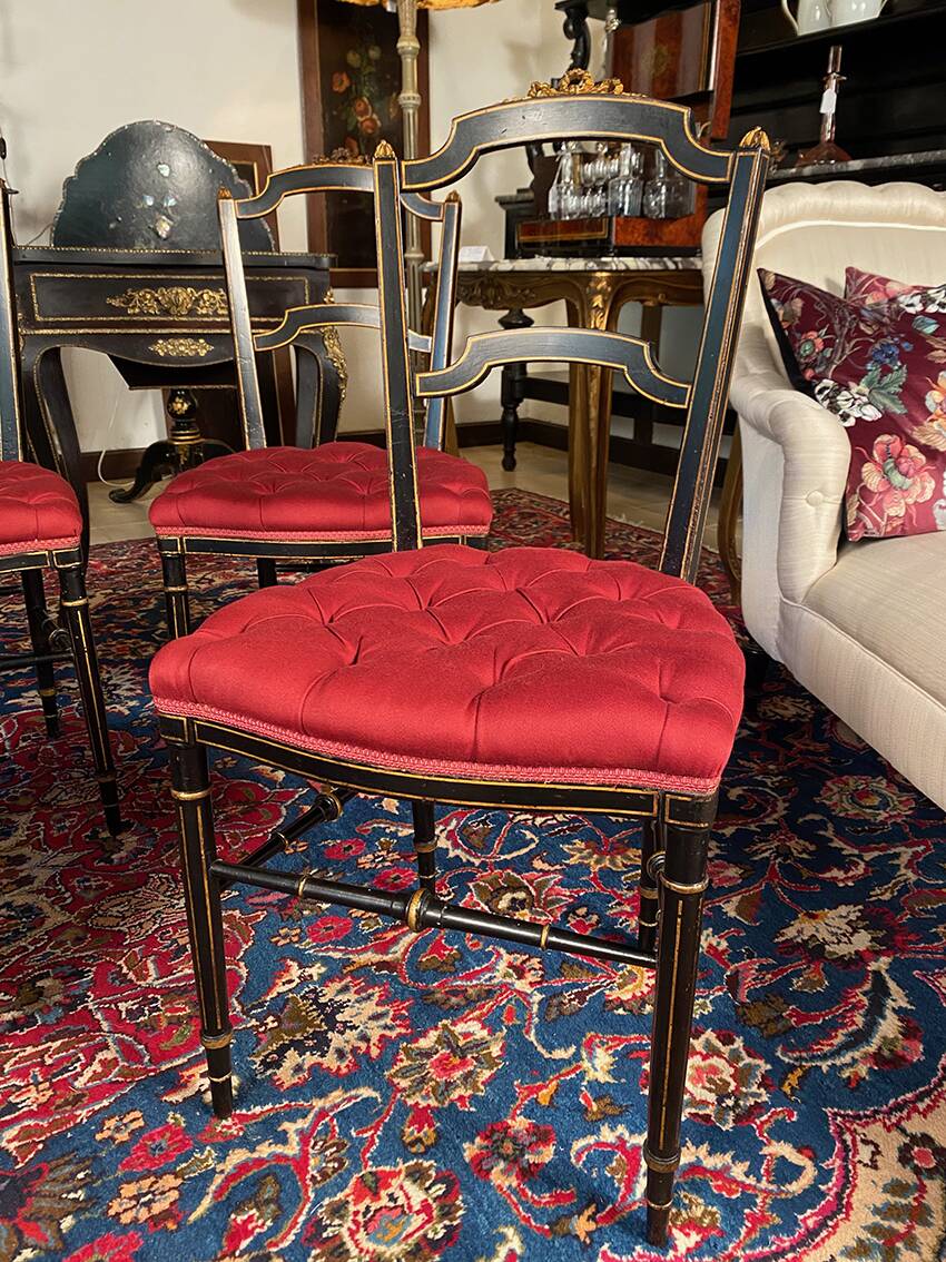 Set of four Napoleon III chairs in black lacquered wood with gold highlights.