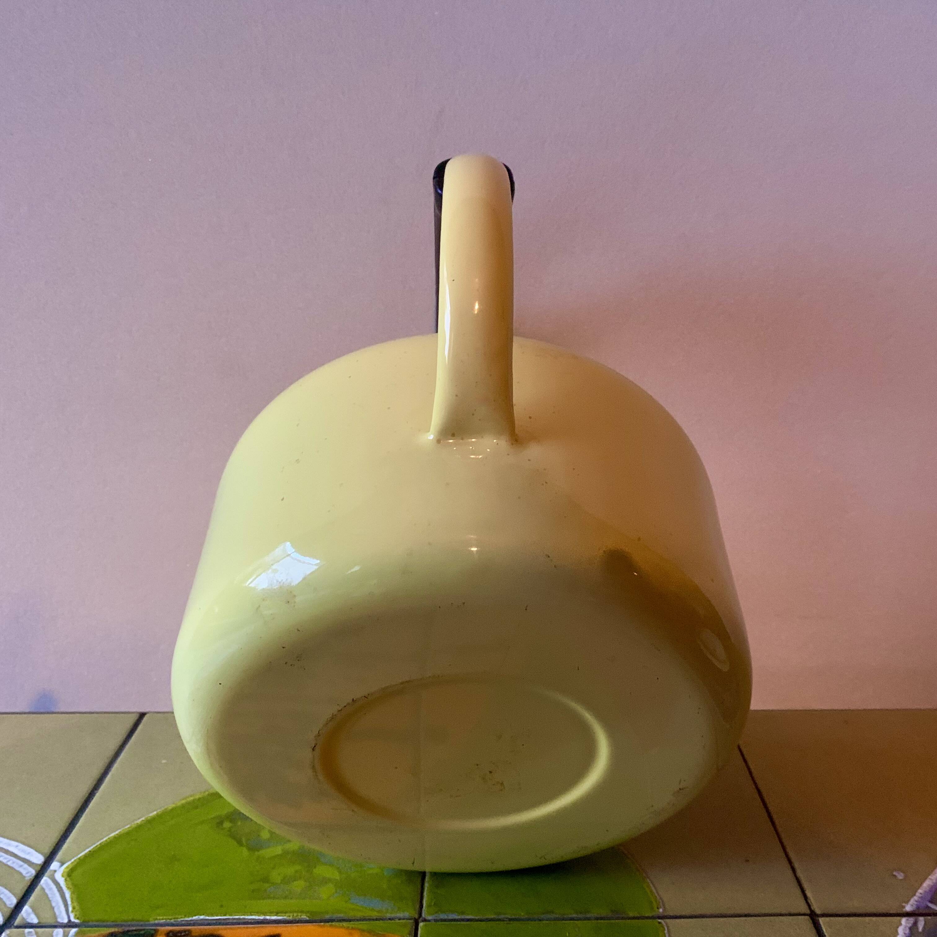 Old kettle in yellow enamelled sheet metal and Bakelite