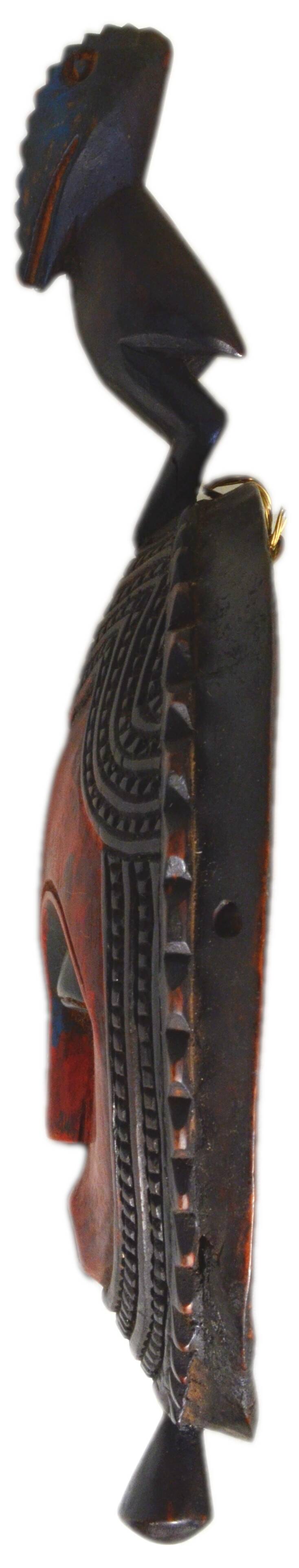 African wooden mask, face topped with a bird.