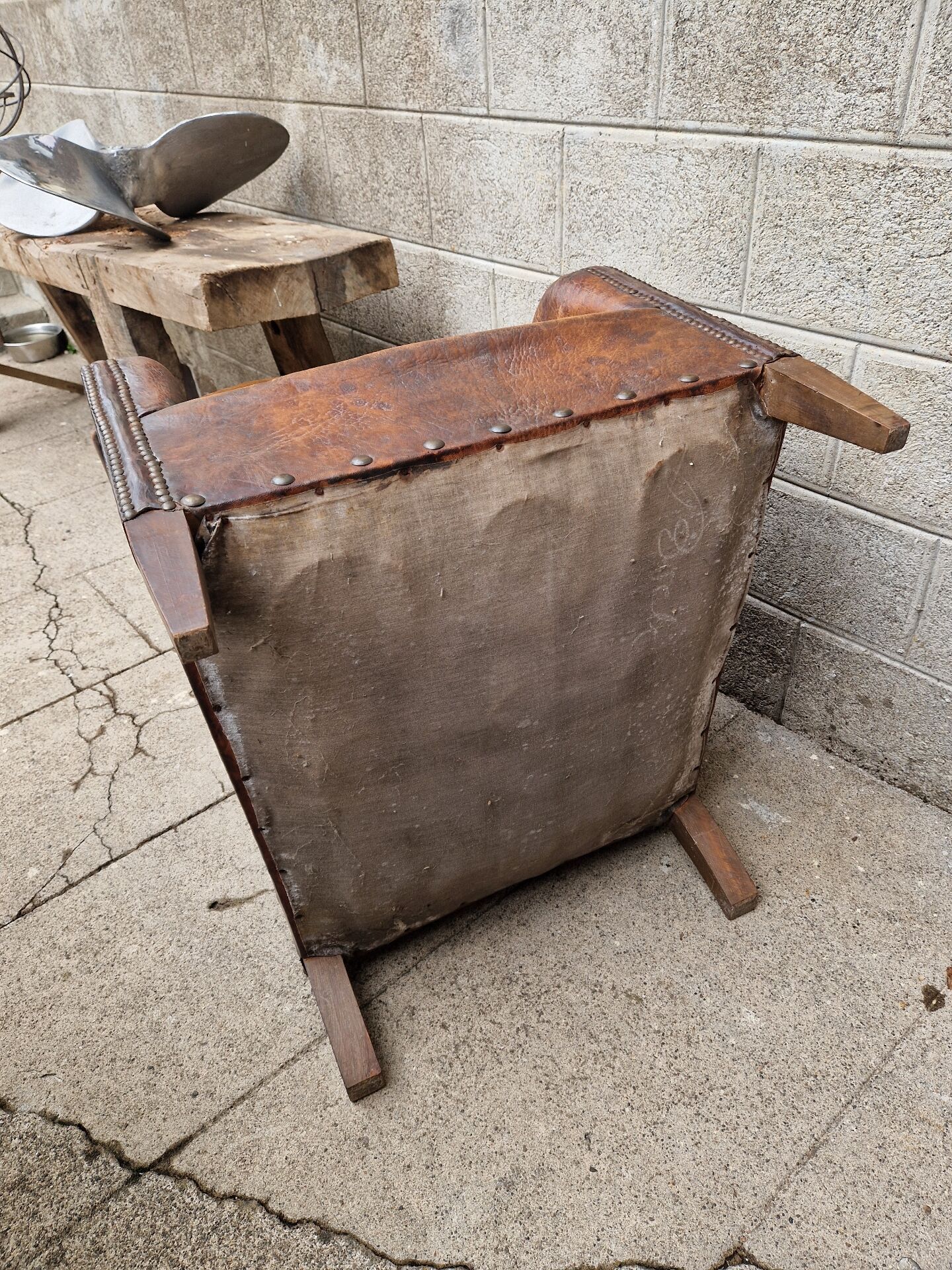 Antique club chair in patinated brown leather, early 20th century English style.