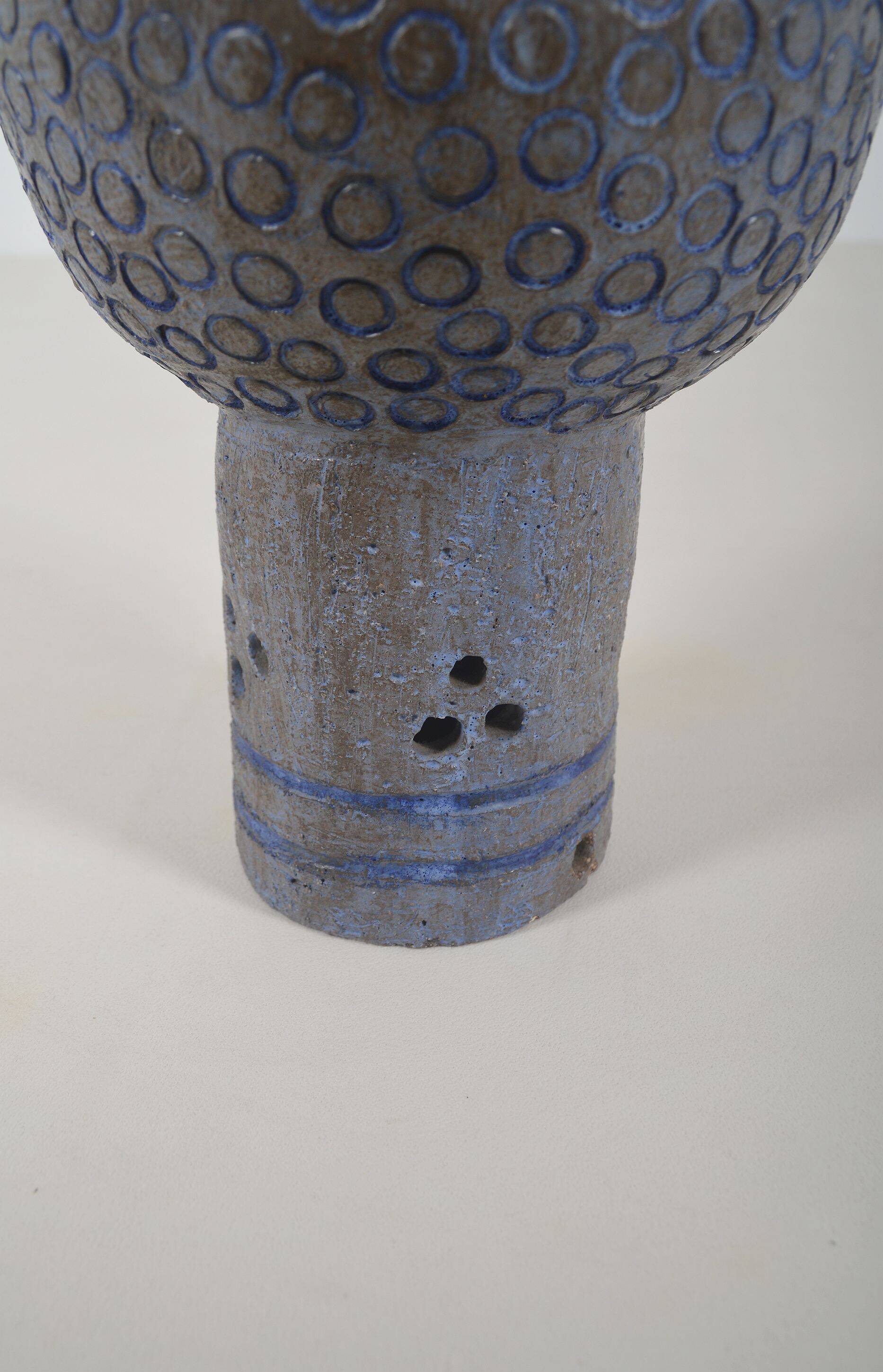 Sculpture en céramique avec des motifs circulaires et une signature.