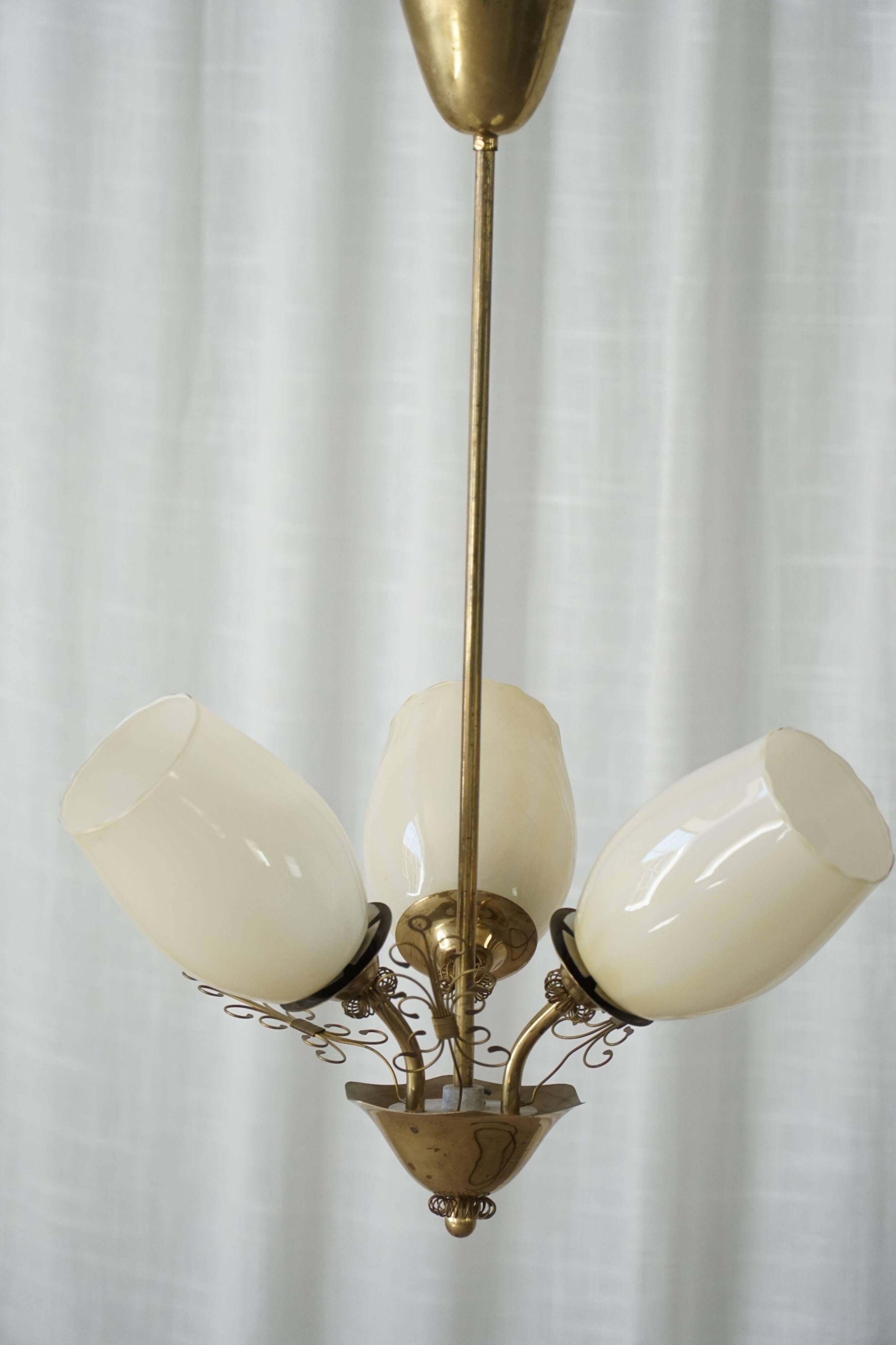 Paavo Tynell for Idman Oy, three-branch chandelier in brass and glass, mid-century, 1940s.
