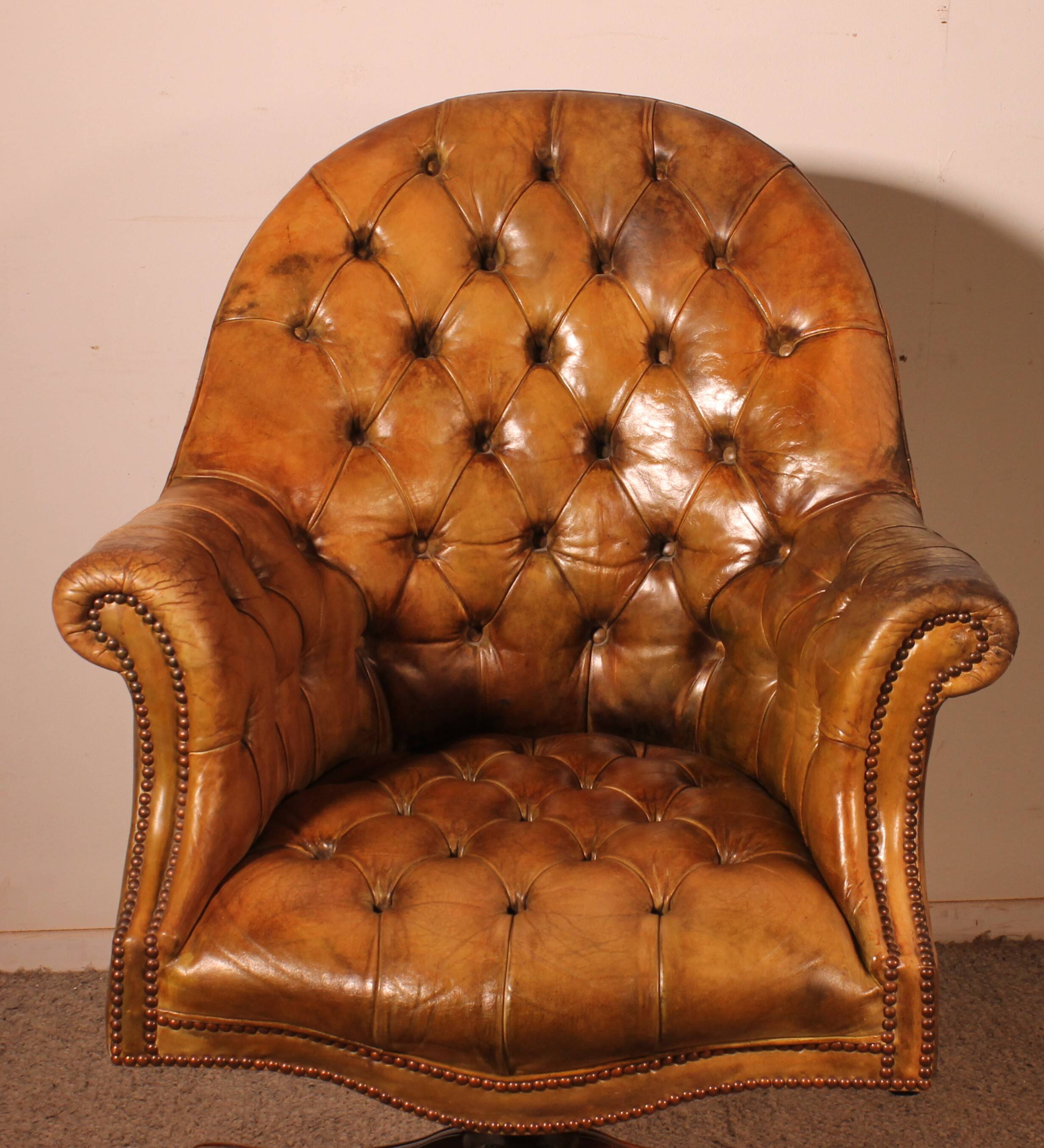 Office chair known as a presidential chair in mahogany and cognac leather.