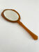 Chic coral orange hand mirror with a mother-of-pearl back – elegant retro style.